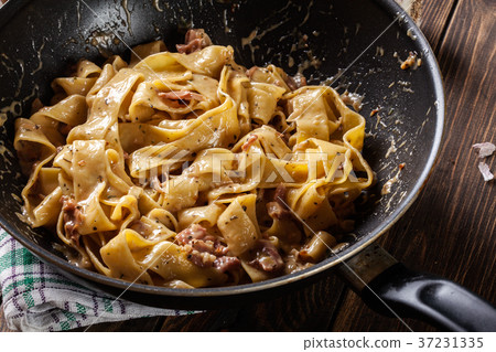 Close-up of pappardelle pasta with prosciutto 37231335