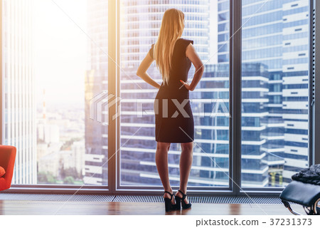 Rear view of elegant female boss standing in 37231373