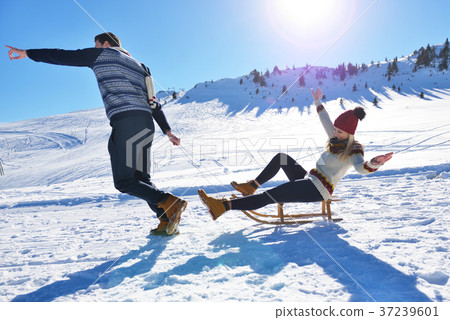 Young Couple Sledding And Enjoying On Sunny Winter 37239601
