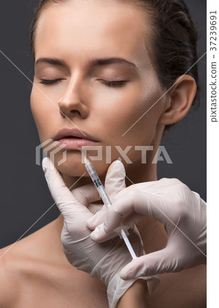 Portrait of young Caucasian woman getting cosmetic Portrait of young Caucasian woman getting cosmetic 37239691
