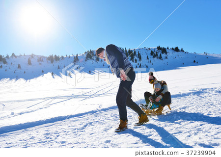 happy young family playing in fresh snow at happy young family playing in fresh snow at 37239904