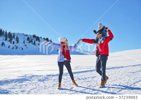happy young family playing in fresh snow at happy young family playing in fresh snow at 37239983