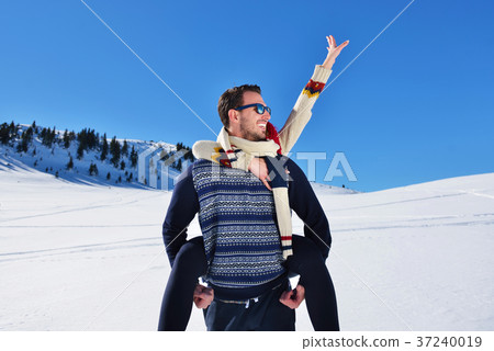 Young couple having fun on snow. Happy man at the Young couple having fun on snow. Happy man at the 37240019