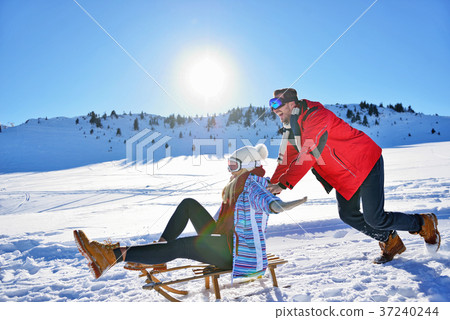Young Couple Sledding And Enjoying On Sunny Winter 37240244
