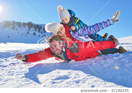 happy young family playing in fresh snow at happy young family playing in fresh snow at 37240295