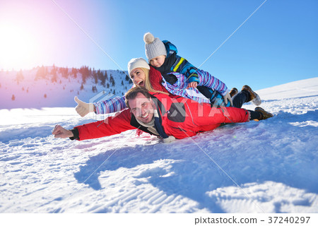 happy young family playing in fresh snow at happy young family playing in fresh snow at 37240297