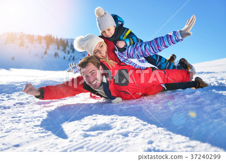 happy young family playing in fresh snow at happy young family playing in fresh snow at 37240299