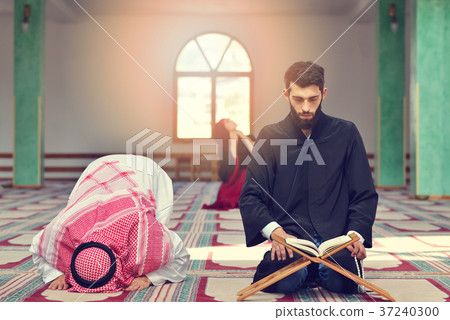 Muslim man and woman praying in mosque Muslim man and woman praying in mosque 37240300