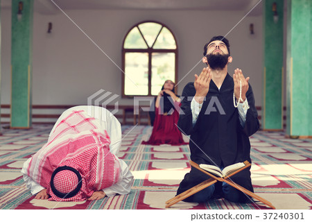 Muslim man and woman praying in mosque Muslim man and woman praying in mosque 37240301