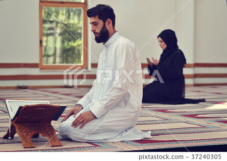 Muslim man and woman praying in mosque Muslim man and woman praying in mosque 37240305