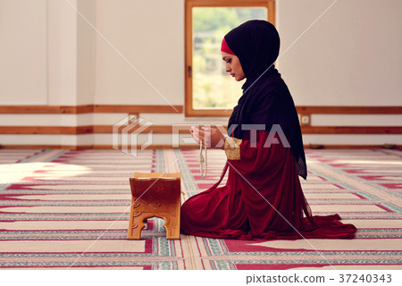 Young muslim woman praying in mosque 37240343