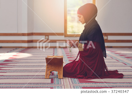 Young muslim woman praying in mosque 37240347