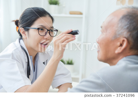 Female Doctor checking to senior man patient eyes. Female Doctor checking to senior man patient eyes. 37241096