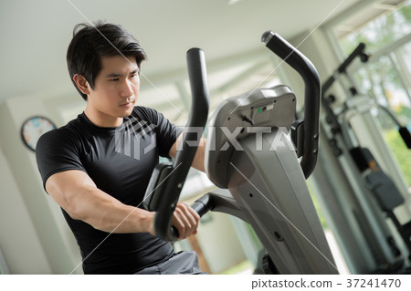 Asian men were cycling in the gym. Asian men were cycling in the gym. 37241470