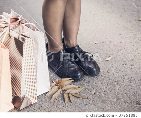 Woman legs wearing black shoes on the street Woman legs wearing black shoes on the street 37251883