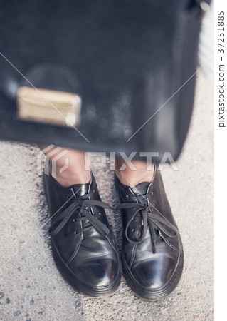 Woman legs wearing black shoes on the street Woman legs wearing black shoes on the street 37251885