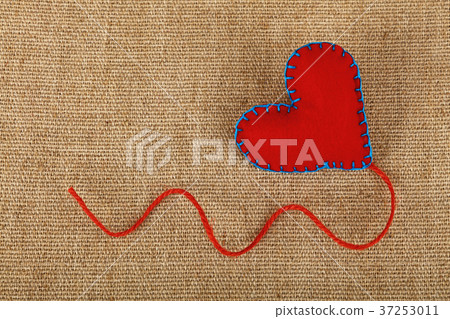 Red felt craft heart over canvas close up Red felt craft heart over canvas close up 37253011
