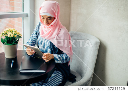 pretty muslim woman use tablet in cafe pretty muslim woman use tablet in cafe 37255329