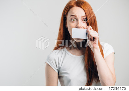 Smiling young woman holding gold credit card ahead 37256270