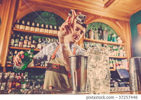 Expert barman is making cocktail at night club. 37257446