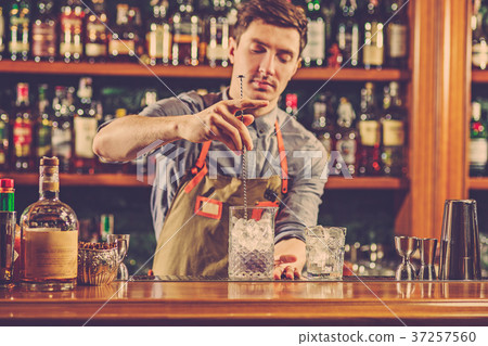 Expert barman is making cocktail at night club. 37257560
