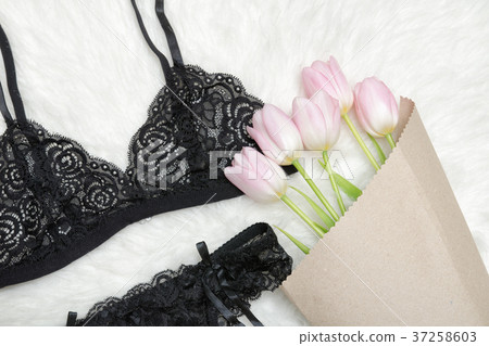 Black lace bodice on white fur. Bouquet tulips Black lace bodice on white fur. Bouquet tulips 37258603