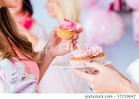 Expecting mother eating cupcake on baby shower 37259647