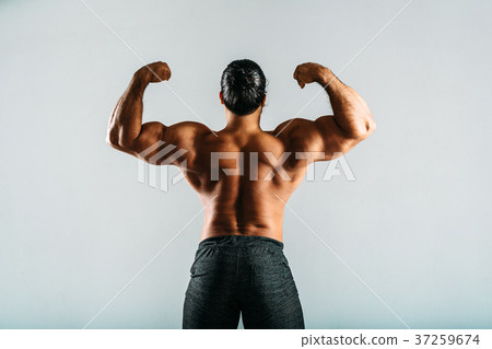 Rear view of a male bodybuilder showing muscles Rear view of a male bodybuilder showing muscles 37259674