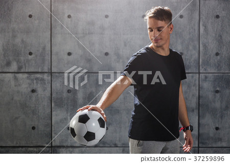 Young man holding soccer ball in hand 37259896