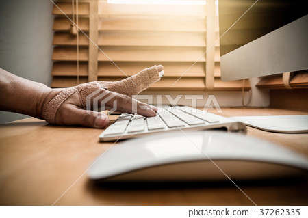 closeup hand with weir wrist to working with computer keyboard with mouse on the wooden table, hardworking and overdo injury concept closeup hand with weir wrist to working with computer keyboard with mouse on the wooden table, hardworking and overdo injury concept 37262335