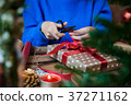 Cutting red ribbon for wrapping present 37271162