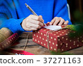 Writing message in a card and giving present 37271163