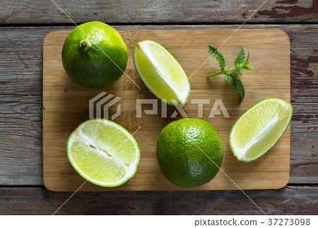 Lime and mint on the kitchen board. Lime, whole Lime and mint on the kitchen board. Lime, whole 37273098
