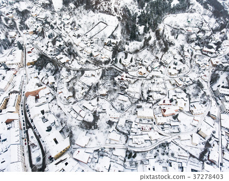 Aerial view of small town with hills in winter. 37278403