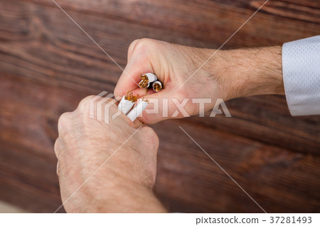 Man breaks cigarettes in his hands. Quit smoking. 37281493