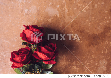 Red roses on brown grunge board background. 37281803