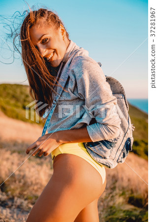 Smiling attractive woman in nature at warm sunset. Smiling attractive woman in nature at warm sunset. 37281967