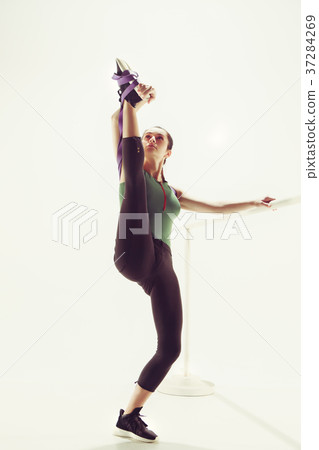 The brunette athletic woman exercising with rubber The brunette athletic woman exercising with rubber 37284269