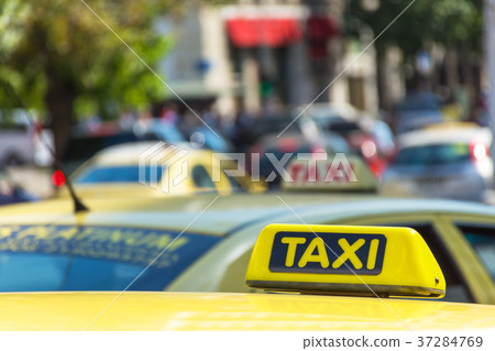 Yellow taxi sign on cab vehicle roof 37284769
