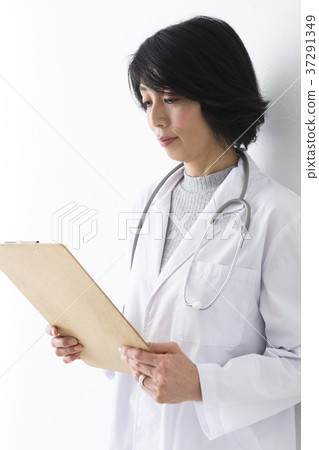 Female doctor looking at medical records Female doctor looking at medical records 37291349