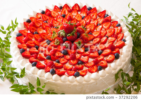 一個很大的奶油蛋糕，有很多草莓的形象 37292206