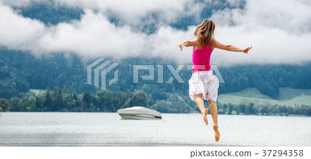 Woman jumping at the lake Woman jumping at the lake 37294358