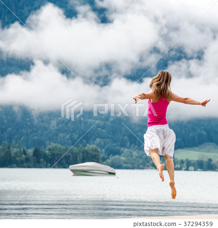 Woman jumping at the lake 37294359