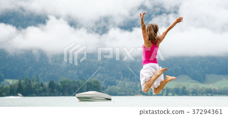 Woman jumping at the lake 37294361