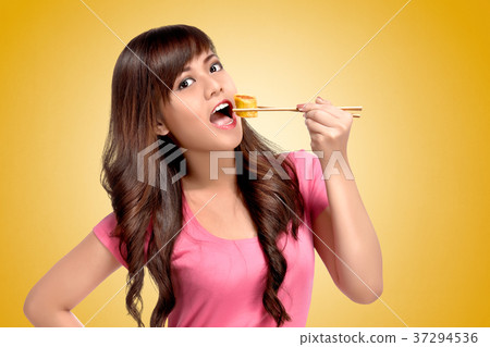 Young asian woman eating sushie with chopsticks 37294536