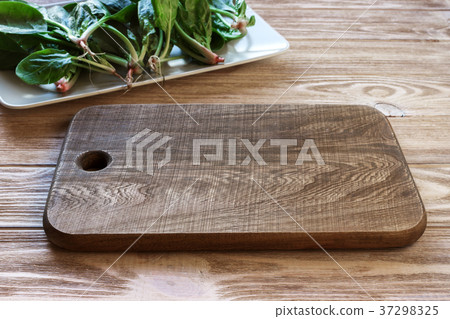 An empty cutting board on the table,spinach leaves 37298325