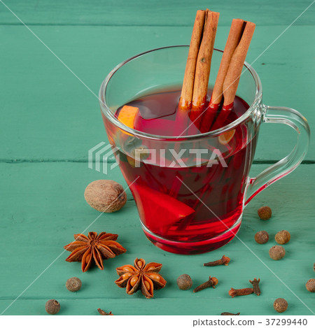 Hot red mulled wine on wooden background  37299440