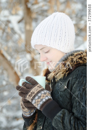 Girl in a white hat look in cup of tea. Winter Girl in a white hat look in cup of tea. Winter 37299688