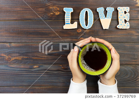 Female hands holding cup of coffee and cookies Female hands holding cup of coffee and cookies 37299769