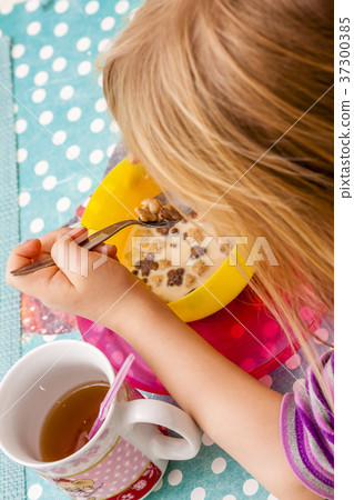 Little girl enjoying the breakfast muesli 37300385
